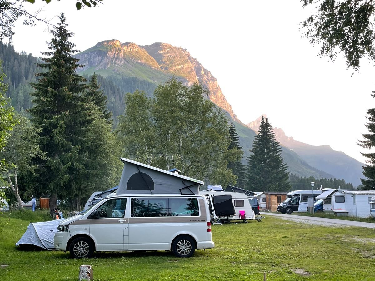 Pop-top campervan conversion, such as a VW Transporter, parked in a scenic location